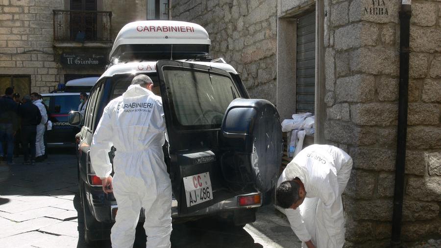 Gli investigatori davanti alla casa dove fu uccisa la famiglia Azzena