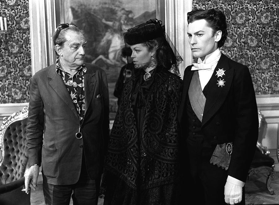 
	Helmut Berger a destra, con Luchino Visconti e Romy Schneider sul set di "Ludwig"


