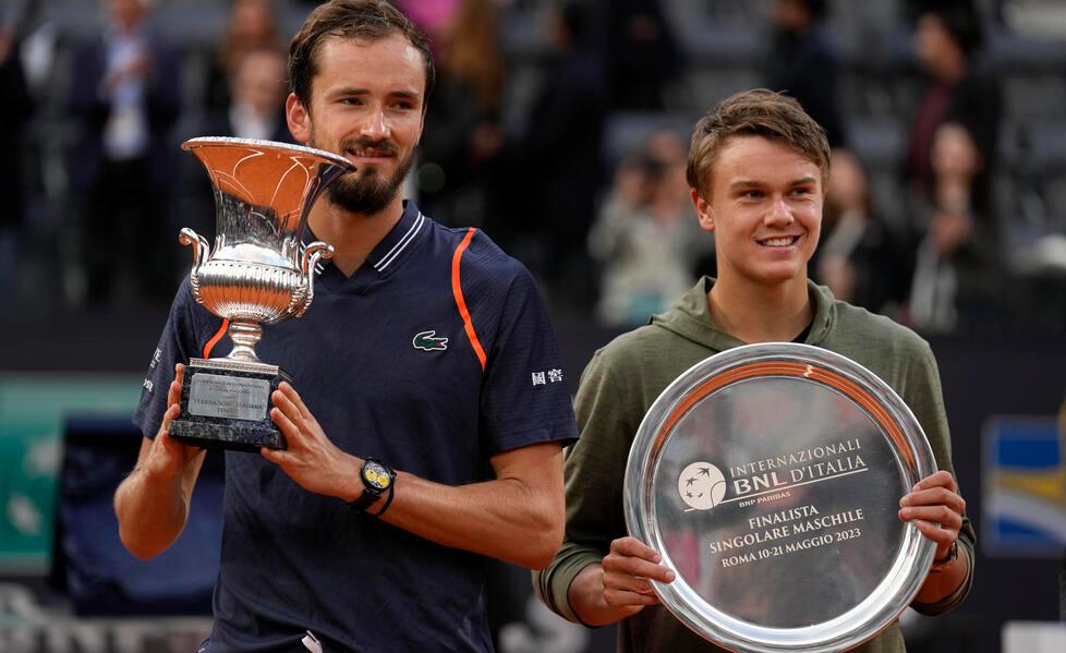 Daniil Medvedev con la coppa degli Internazionali d’Italia dopo il successo su Rune (a destra)