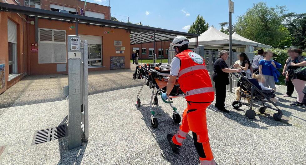 Un volontario porta una barella dentro la scuola (foto studio Nucci)