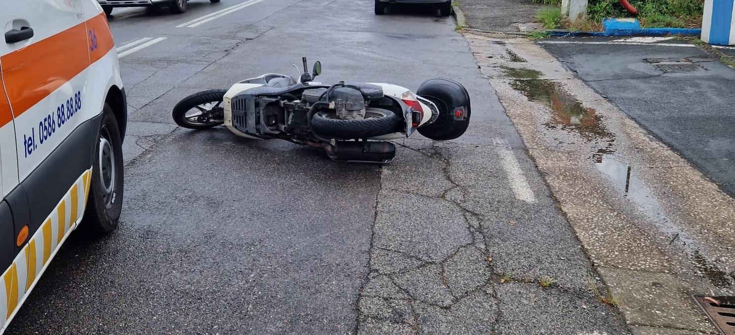 Il motorino sull'asfalto dopo l'incidente e l'ambulanza Svs sul posto