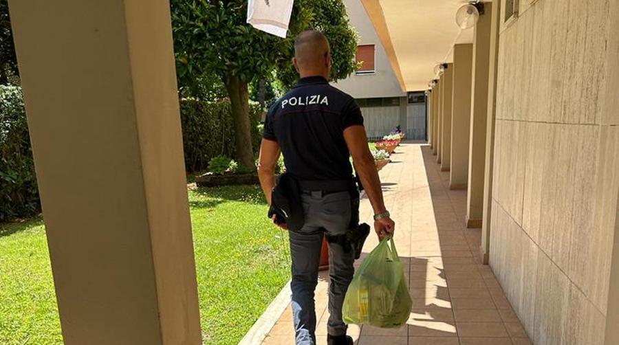 Un poliziotto mentre porta la spesa all'anziana