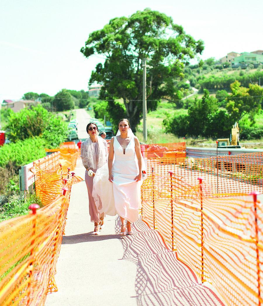 
	La sposa Sarah Della Casa e la sua testimone attraversano il ponte Siligo-Banari <em>(foto Laura Francesconi)</em>

