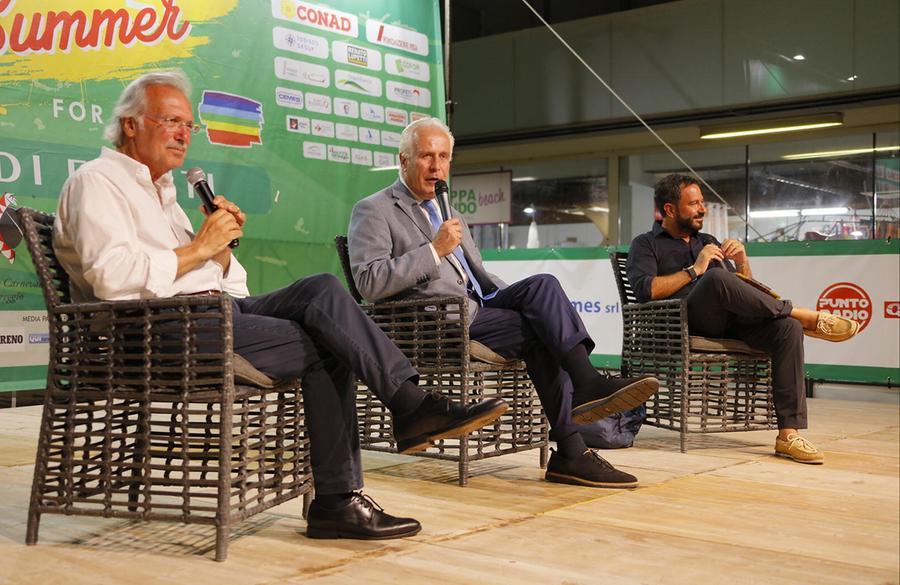 
	Da sinistra il giornalista Massimo Marini, il presidente della Regione Eugenio Giani e il direttore de Il Tirreno, Luciano Tancredi, sul palco di Eliopoli a Calambrone (Foto di Fabio Muzzi)


