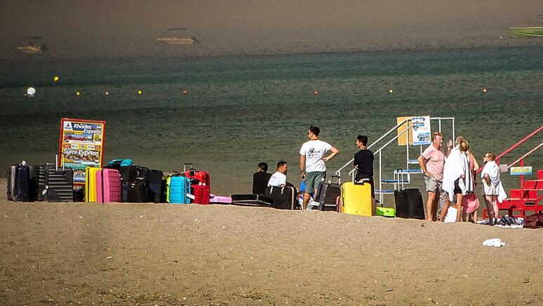 Vacanze ancora in spiaggia. Pure tra gli incendi di Rodi