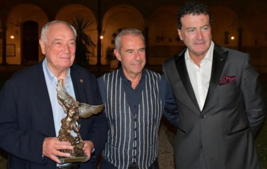
	Carlo Palli riceve la statuetta del San Michele Arcangelo, simbolo del Premio Cerreto da Fabrizio Tesi e Fernando Meoni

