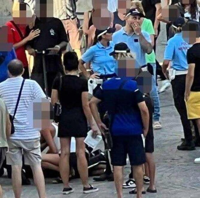 Alessandro a terra immobilizzato. Intorno la folla e gli agenti della polizia municipale