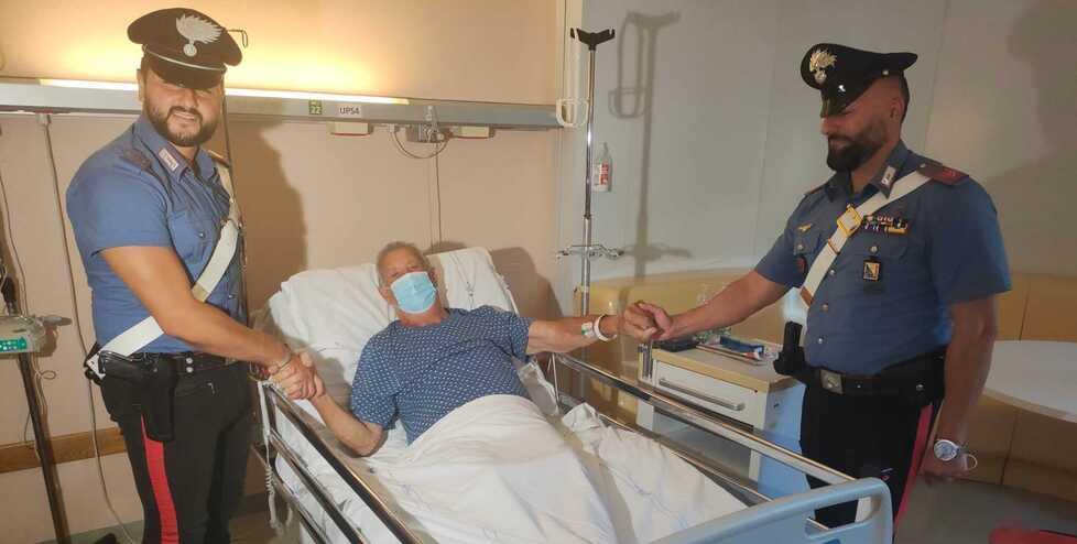 Il 78enne Albo Corallini nel suo letto di ospedale a Villamarina durante l’incontro con i due carabinieri che lo hanno salvato: il vicebrigadiere Pasquale Giordano (a sinistra) e l’appuntato scelto Nicola Rossi