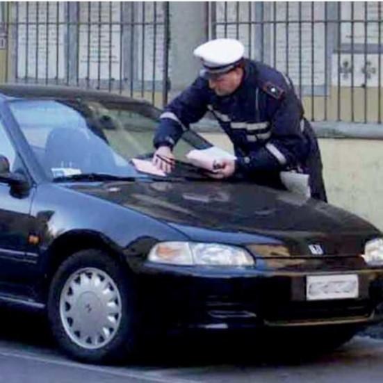 Un vigile che affissa una multa (foto d'archivio)
