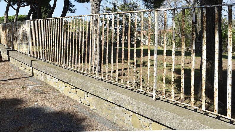 Il muretto con l’inferriata che delimita lo sgambatoio su viale della Resistenza