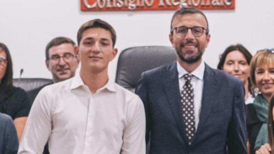 
	A sinistra il 16enne premiato in consiglio regionale accanto al presidente del consiglio, Antonio Mazzeo

