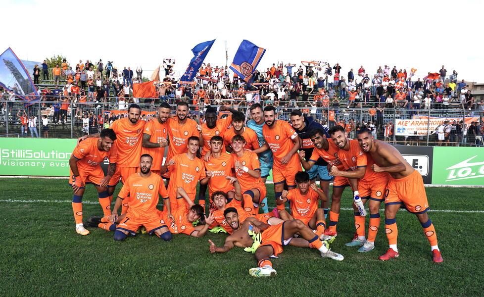 Foto di squadra alle spalle della curva ospite con i tifosi arancioni per la Pistoiese al termine della gara (foto Nucci)