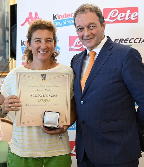 La presidente del circolo scherma Piombino Daria Mai mostra orgogliosa l’attestato del premio ricevuto insieme al ds e preparatore atletico Andrea Mariotti