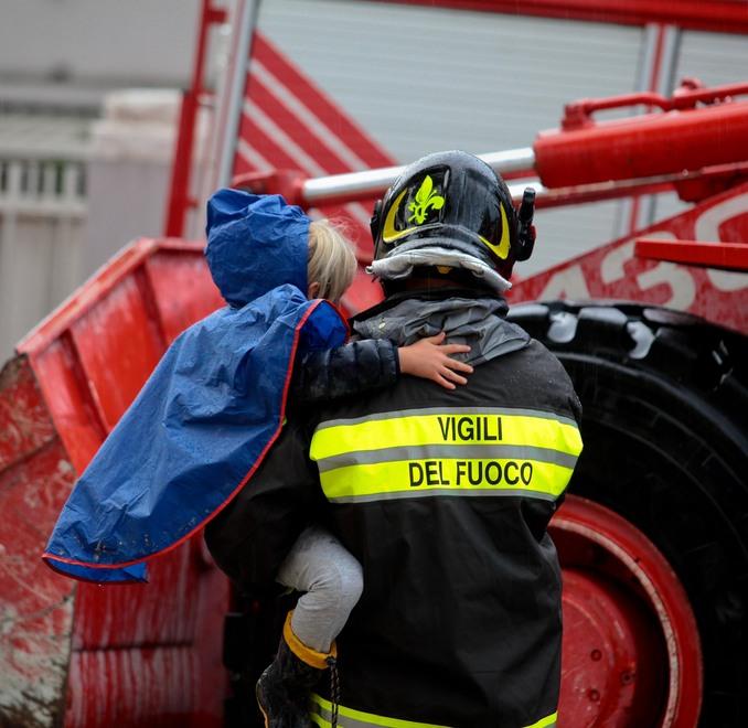 In alto una bambina portata in salvo da un vigile del fuoco