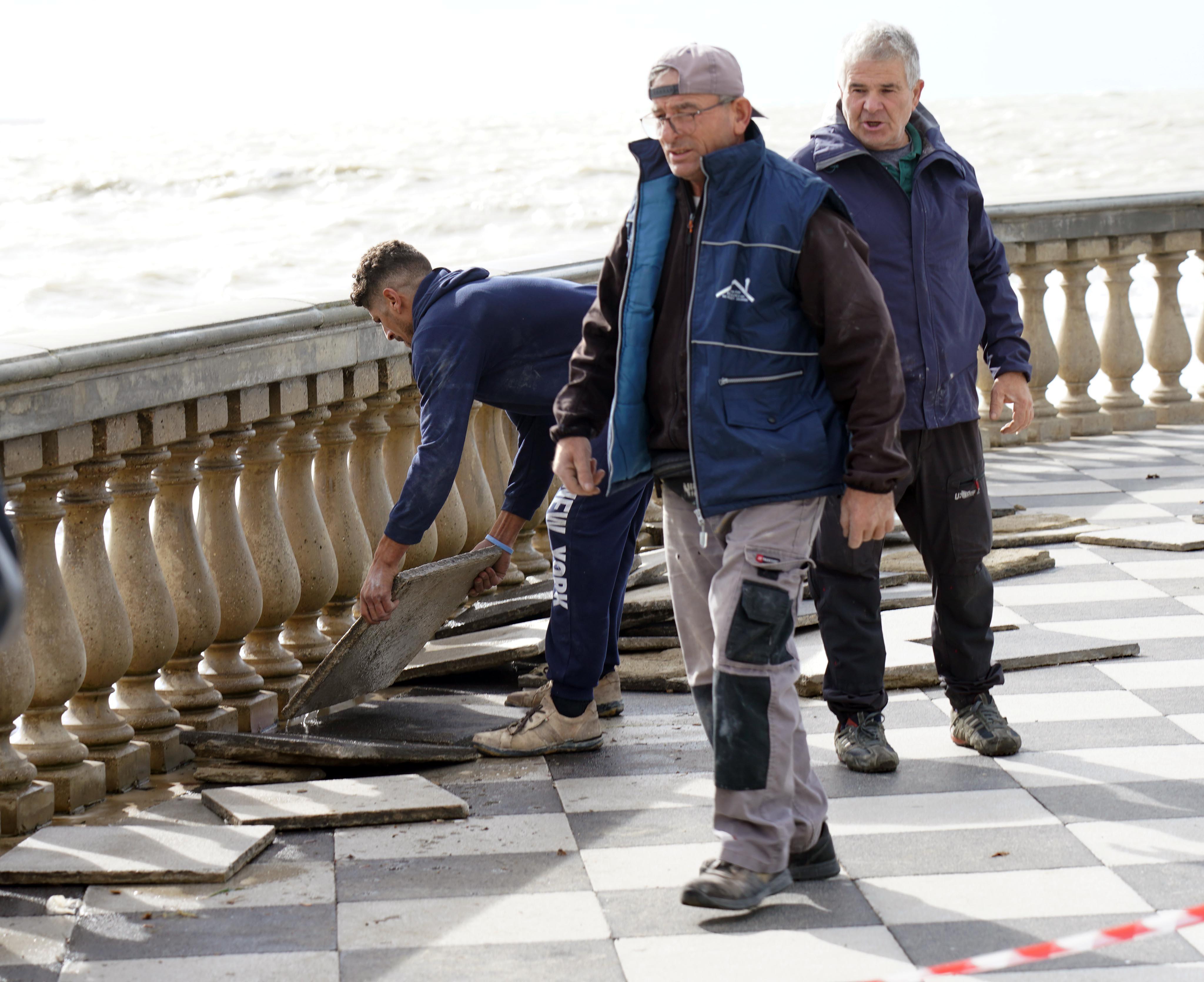 Operai al lavoro per la rimozione delle mattonelle rotte (foto Franco Silvi)