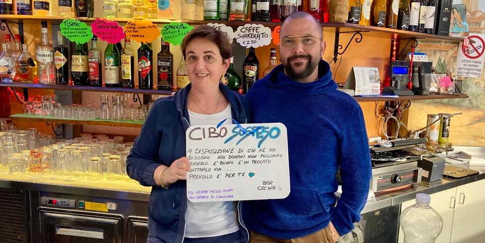 I titolari del Bar Cecina con il cartello che indica il “Cibo sospeso”