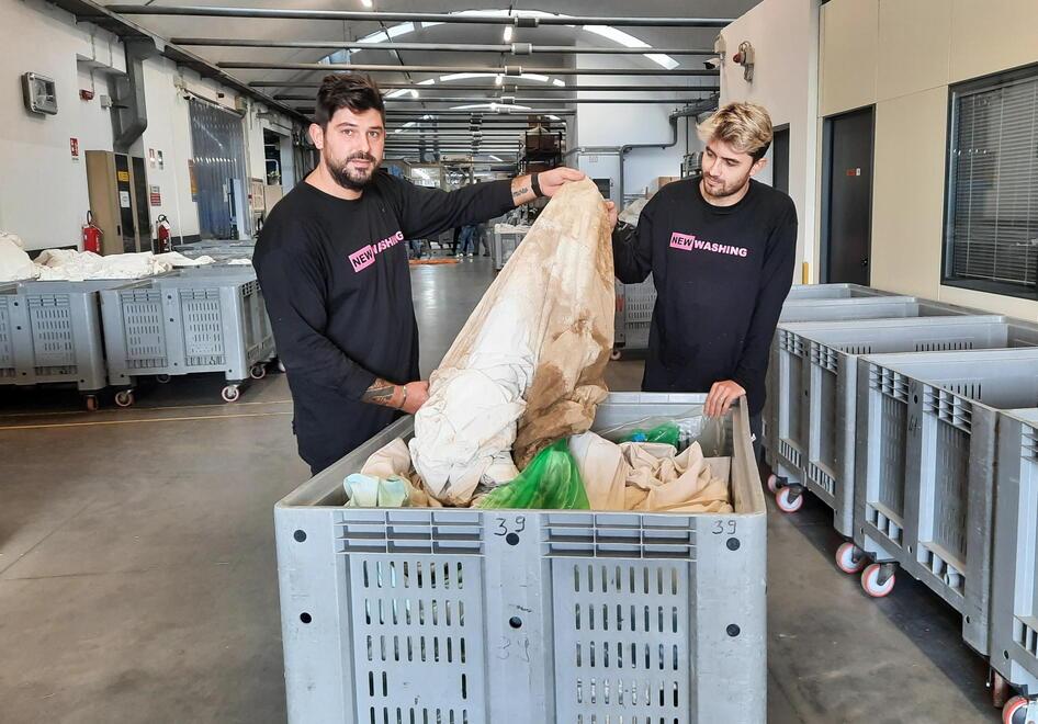Due dipendenti della New Washing coi capi da lavare