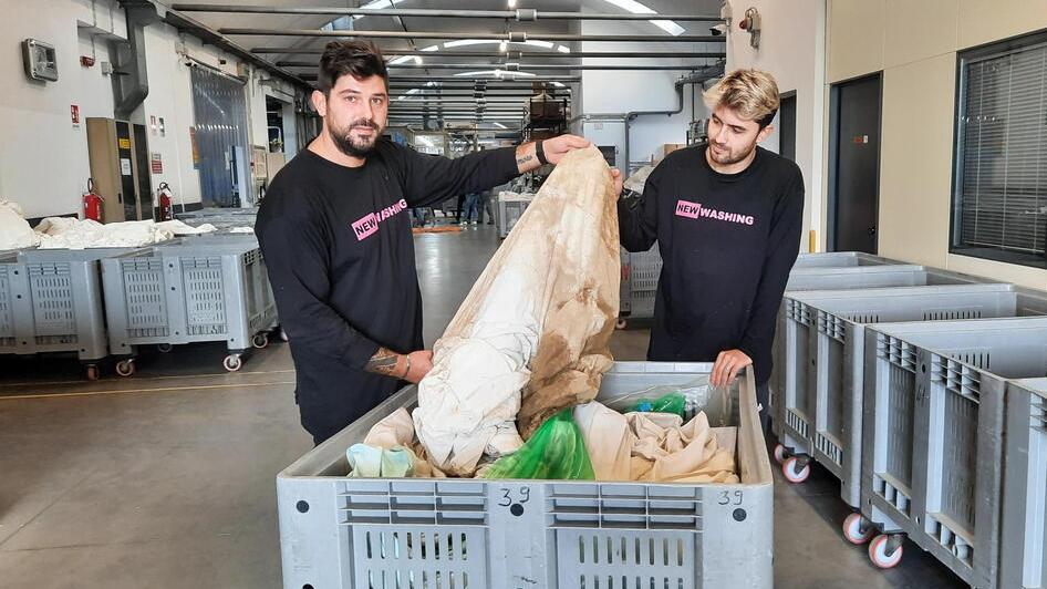 Due dipendenti della New Washing coi capi da lavare