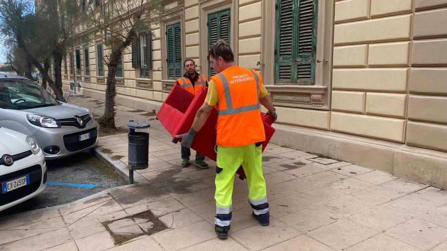 Due operatori dell'Aamps rimuovono il divano abbandonato in via Malta