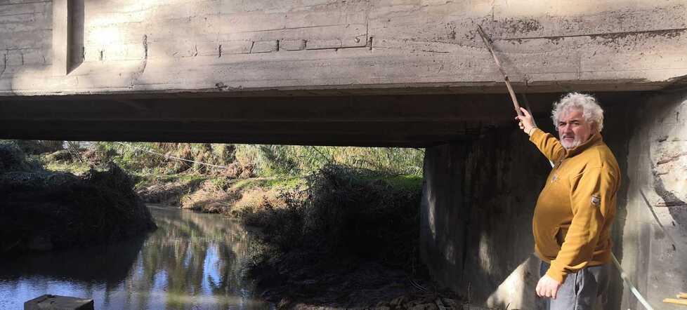 Manrico Bendinelli mentre mostra il livello dove arrivava l’acqua sul ponte sulla 206