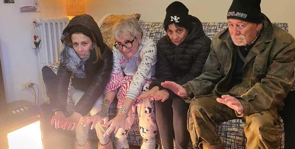 La foto simbolo dello scorso anno con la famiglia al freddo che cerca di scaldarsi intorno a un piccolo radiatore