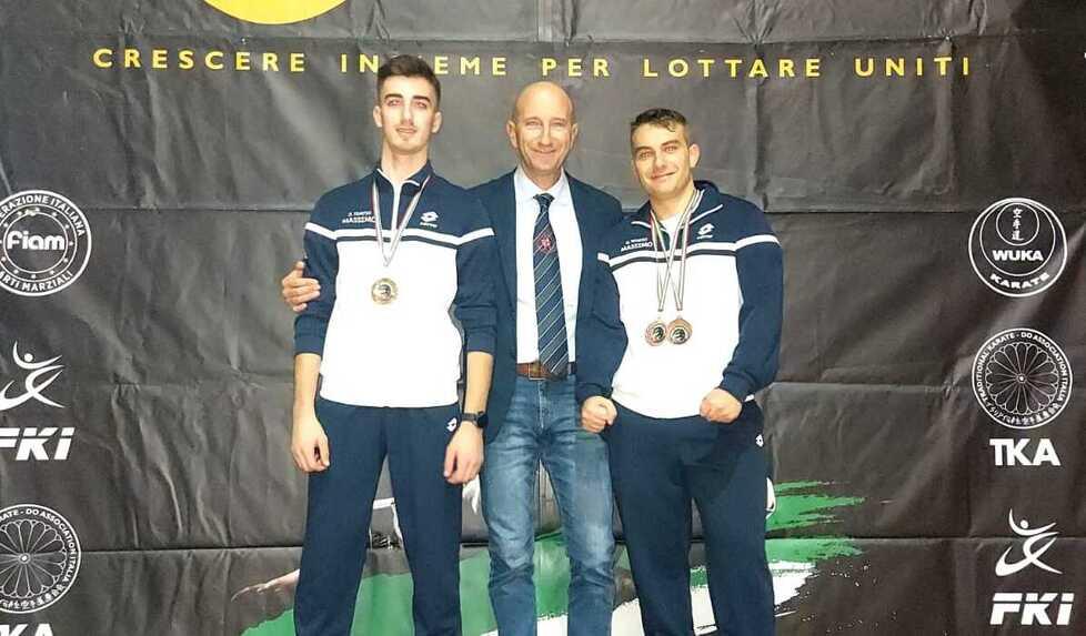 Giacomo Felice Serrao e Tommaso Bocchi sul podio assieme al maestro Massimo Serrao: grande affermazione degli atleti apuani impegnati nelle gare nel palazzetto dello sport di Montaldo di Castro