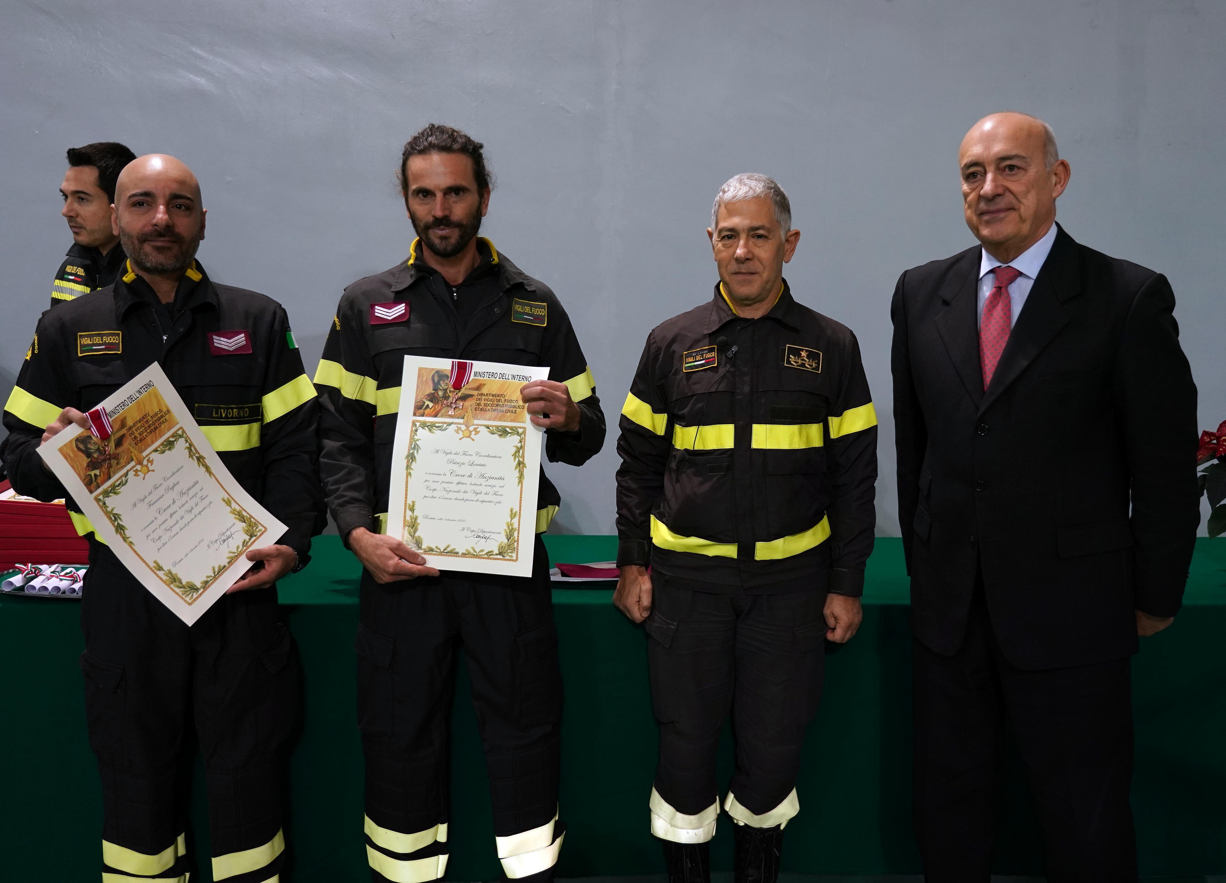 Due pompieri premiati con il comandante provinciale dei vigili del fuoco, Ugo D'Anna, e il prefetto D'Attilio