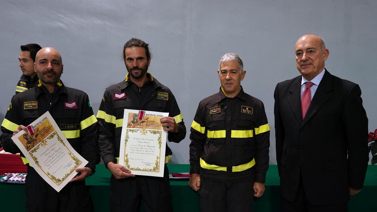 Due pompieri premiati con il comandante provinciale dei vigili del fuoco, Ugo D'Anna, e il prefetto D'Attilio