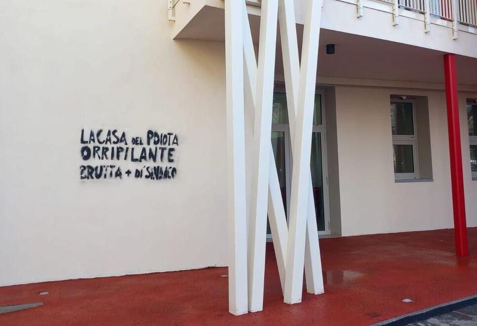 La scritta offensiva, anche nei confronti del sindaco, realizzata con spray nero sulla facciata della nuova struttura polivalente di Gambassi Terme