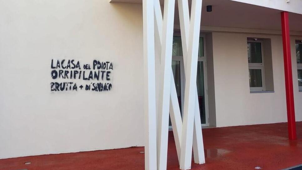 La scritta offensiva, anche nei confronti del sindaco, realizzata con spray nero sulla facciata della nuova struttura polivalente di Gambassi Terme