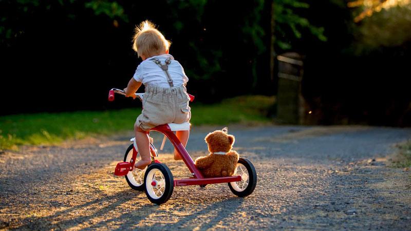 Un bambino a bordo di un triciclo simile a quello usato dal piccolo di due anni che ieri si è momentaneamente allontanato dai genitori (foto d’archivio)
