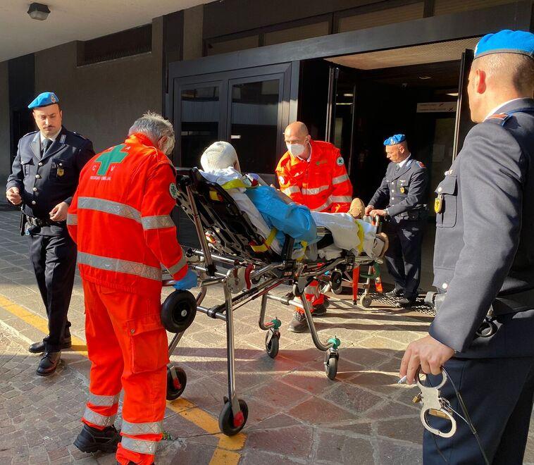 Testa fasciata e sdraiato in barella arriva in tribunale di Reggio Emilia dopo la rissa