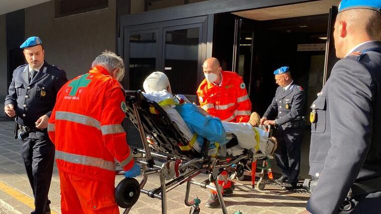 Testa fasciata e sdraiato in barella arriva in tribunale di Reggio Emilia dopo la rissa