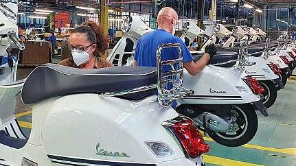 Operai al lavoro sulla linea di montaggio della Vespa durante la pandemia all’interno della Piaggio di Pontedera