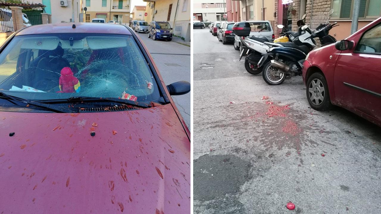 Il lunotto dell’auto danneggiato dal barattolo e le tracce di polpa di pomodoro sulla strada
