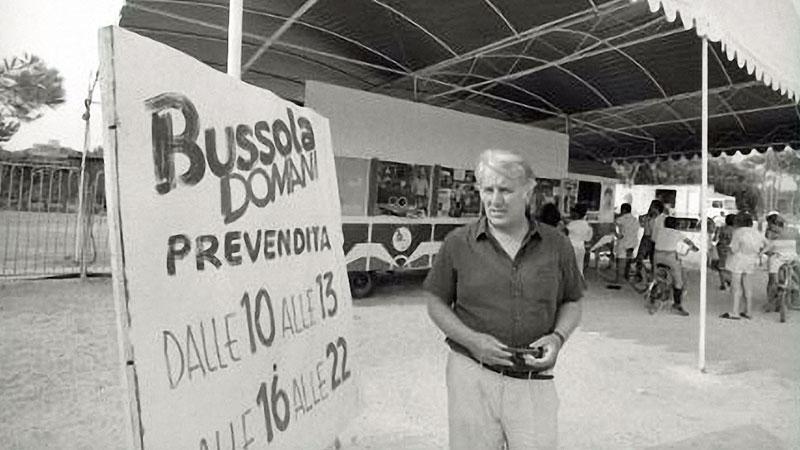 Una immagine storica di Sergio Bernadini davanti al cartellone di Bussoladomani, il tendone lanciato a Lido di Camaiore