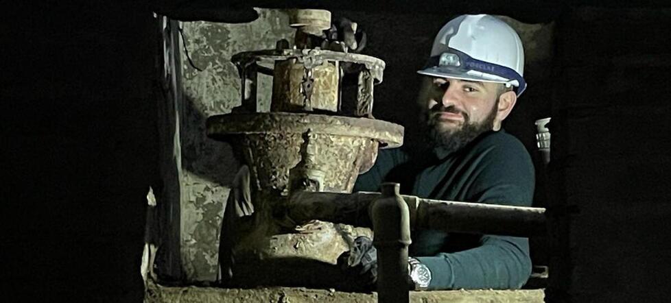 Il giovane studente di Egittologia Leonardo Baroncini all’interno della sala macchine a 2,5 metri di profondità alle prese con la scoperta della turbina