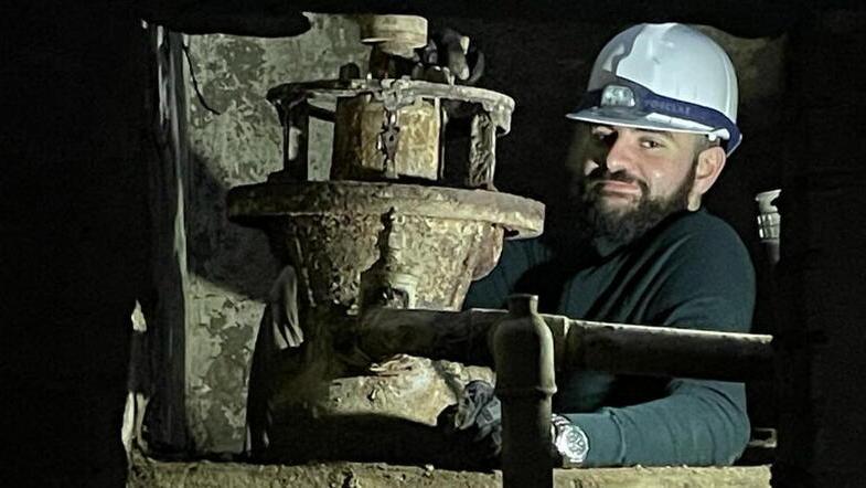 Il giovane studente di Egittologia Leonardo Baroncini all’interno della sala macchine a 2,5 metri di profondità alle prese con la scoperta della turbina