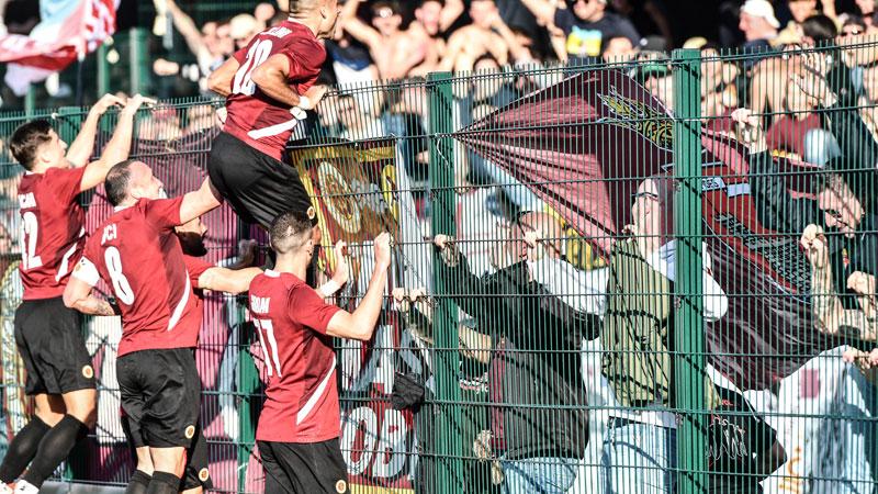 L’esultanza della squadra sotto al settore dei tifosi amaranto dopo il gol di Tanasa
