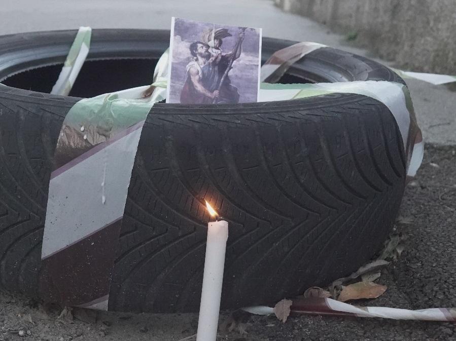 
	Lo pneumatico corredato da candela accesa e foto di un santo collocati lungo via della Quercia sopra una buca (foto Enzo Russo)

