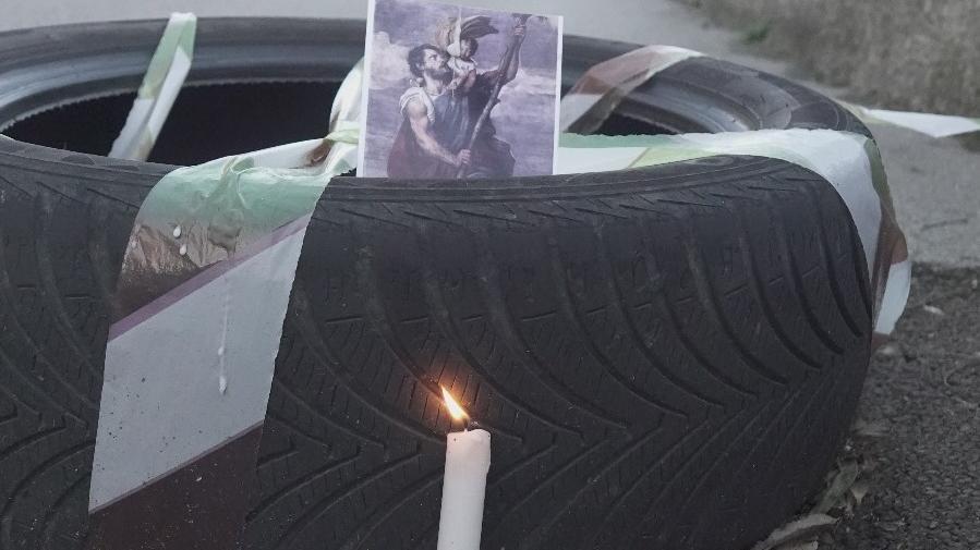 Lo pneumatico corredato da candela accesa e foto di un santo collocati lungo via della Quercia sopra una buca (foto Enzo Russo)