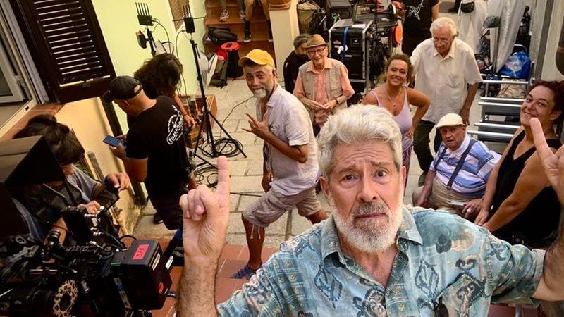 Luglio 2023: Alessandro Benvenuti in un selfie con alle spalle la troupe dei Delitti del BarLume