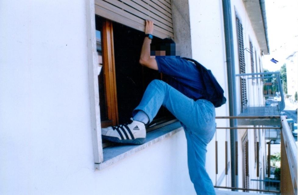 Un ladro mentre entra all’interno di una casa (foto d’archivio)