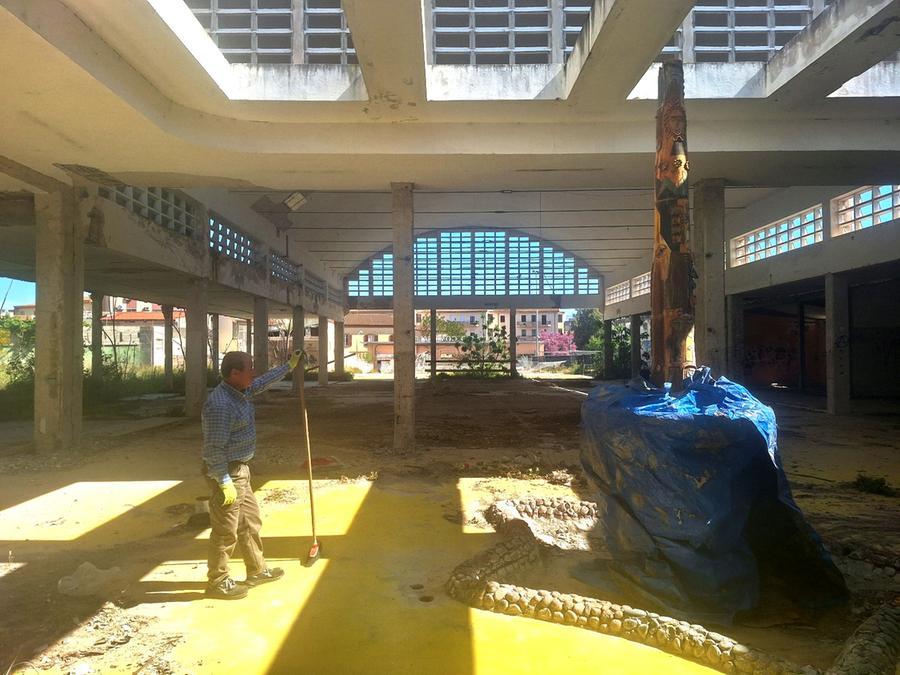 
	Un operaio davanti alla fontana del Corriga ricoperta con un telo dentro al rudere del mercato civico

