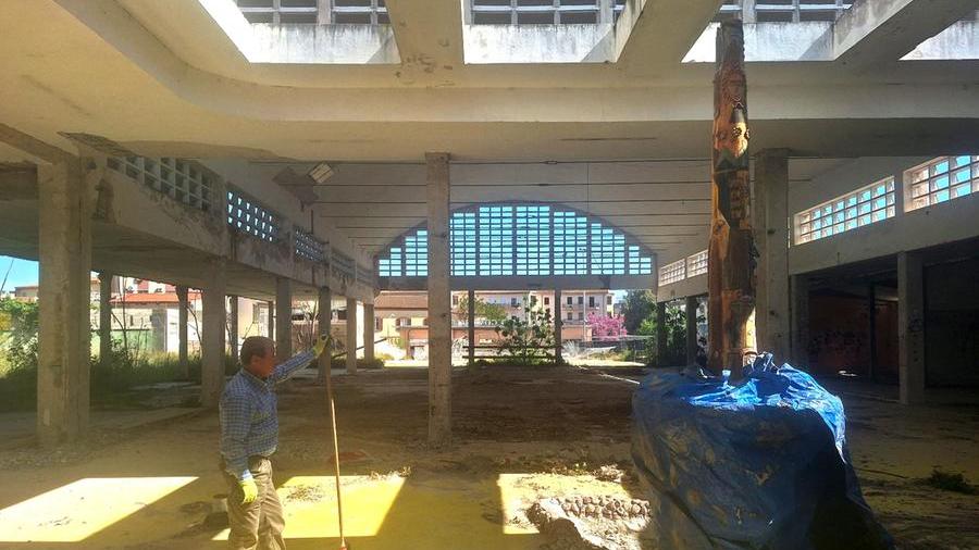 Un operaio davanti alla fontana del Corriga ricoperta con un telo dentro al rudere del mercato civico