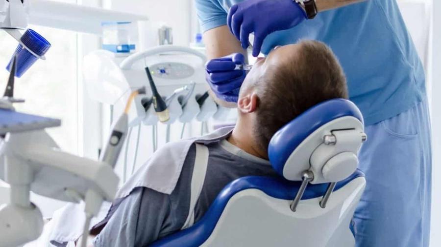 Un dentista mentre esegue un intervento su un paziente