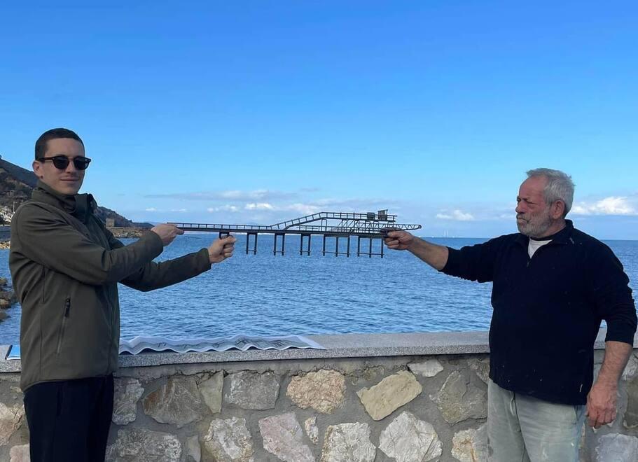 A sinistra l’assessore Mattia Guerrini e l’artista Luca Polesi con la miniatura del pontile sul molo proprio dove dovrebbe essere posizionata la teca