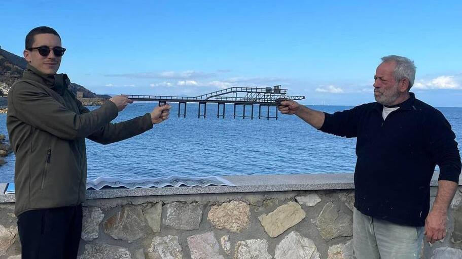 A sinistra l’assessore Mattia Guerrini e l’artista Luca Polesi con la miniatura del pontile sul molo proprio dove dovrebbe essere posizionata la teca