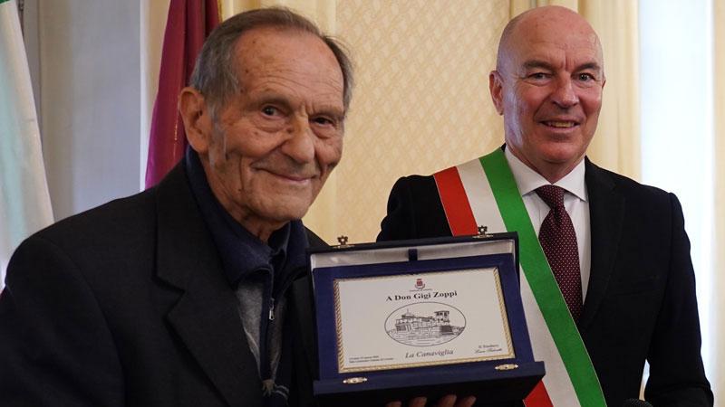 Don Luigi Zoppi mentre riceve la Canaviglia dal sindaco (foto Silvi)