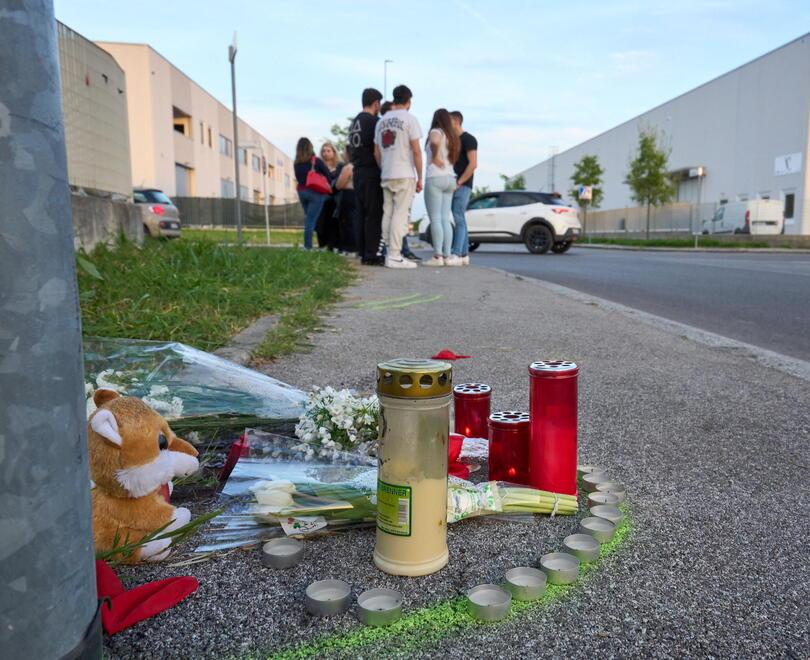 Fiori e lumini sul luogo dell’incidente mortale. Sullo sfondo gli amici di Tommaso Comelei